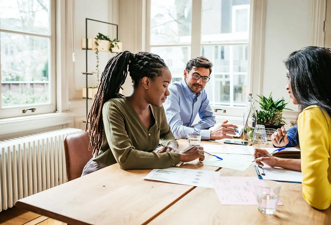 Coworkers at a table reviewing documents