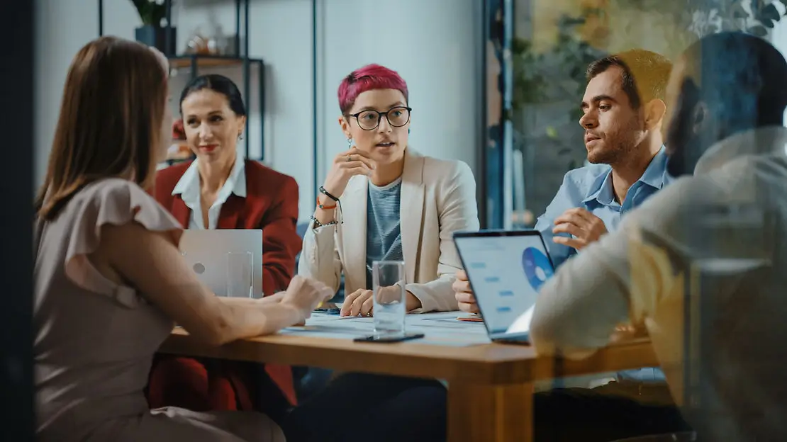 Group of coworkers sitting around a table talking