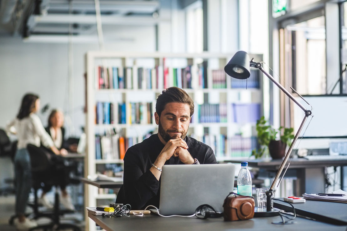 Man looking at laptop in an office space 