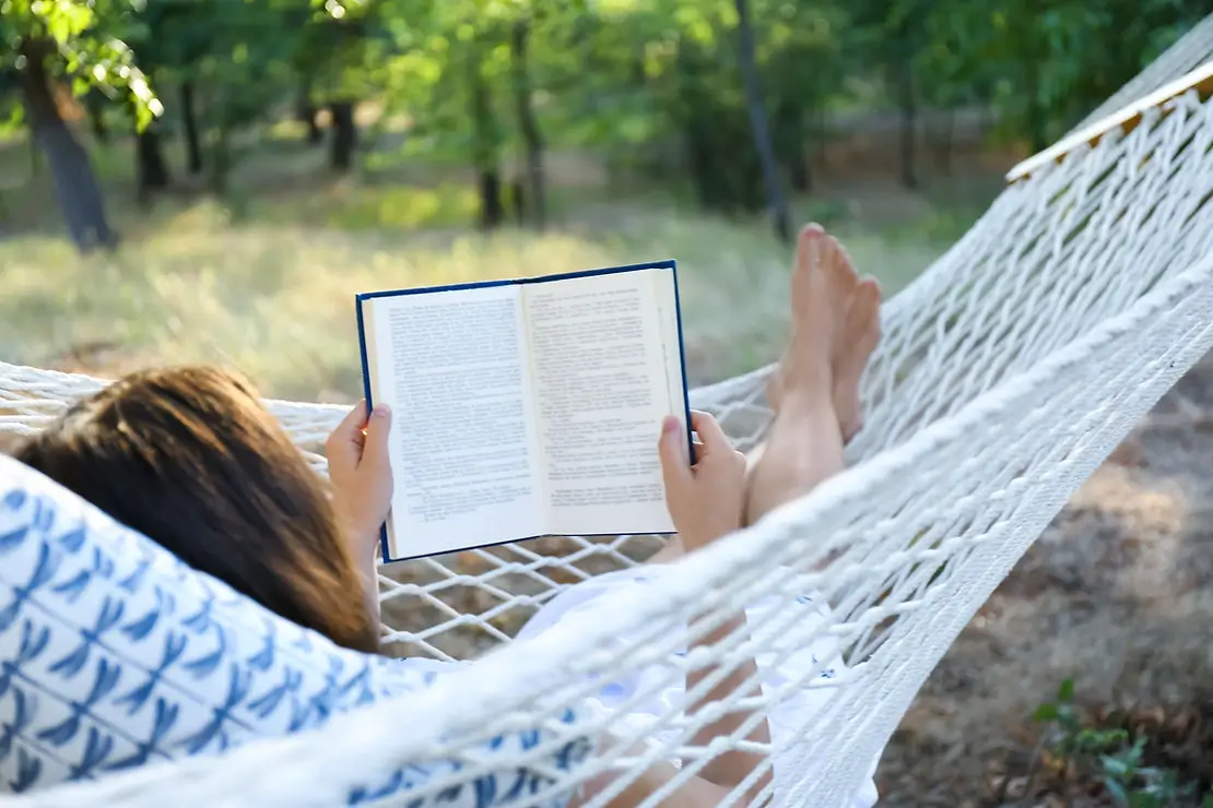 Person in  a hammok reading a book