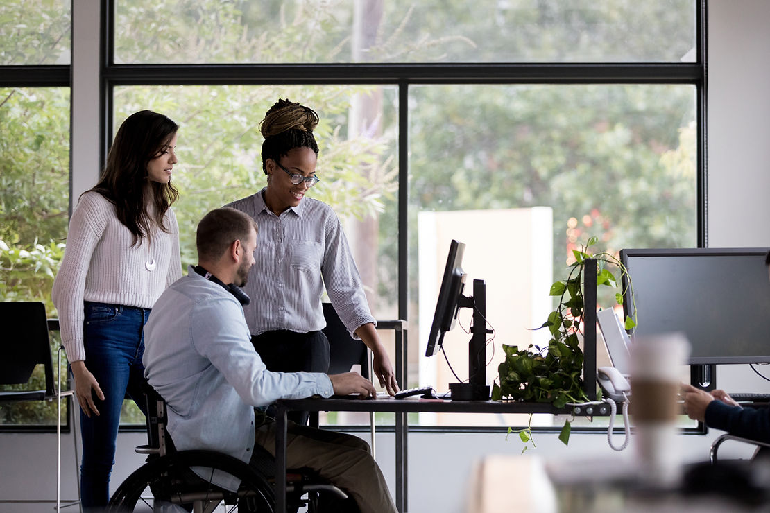 Three people working together looking at a computer screen