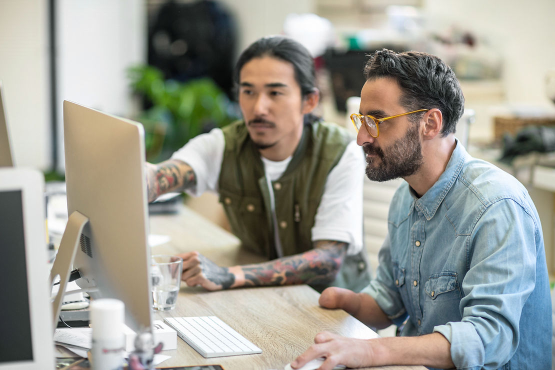 Two men focused looking at a computer