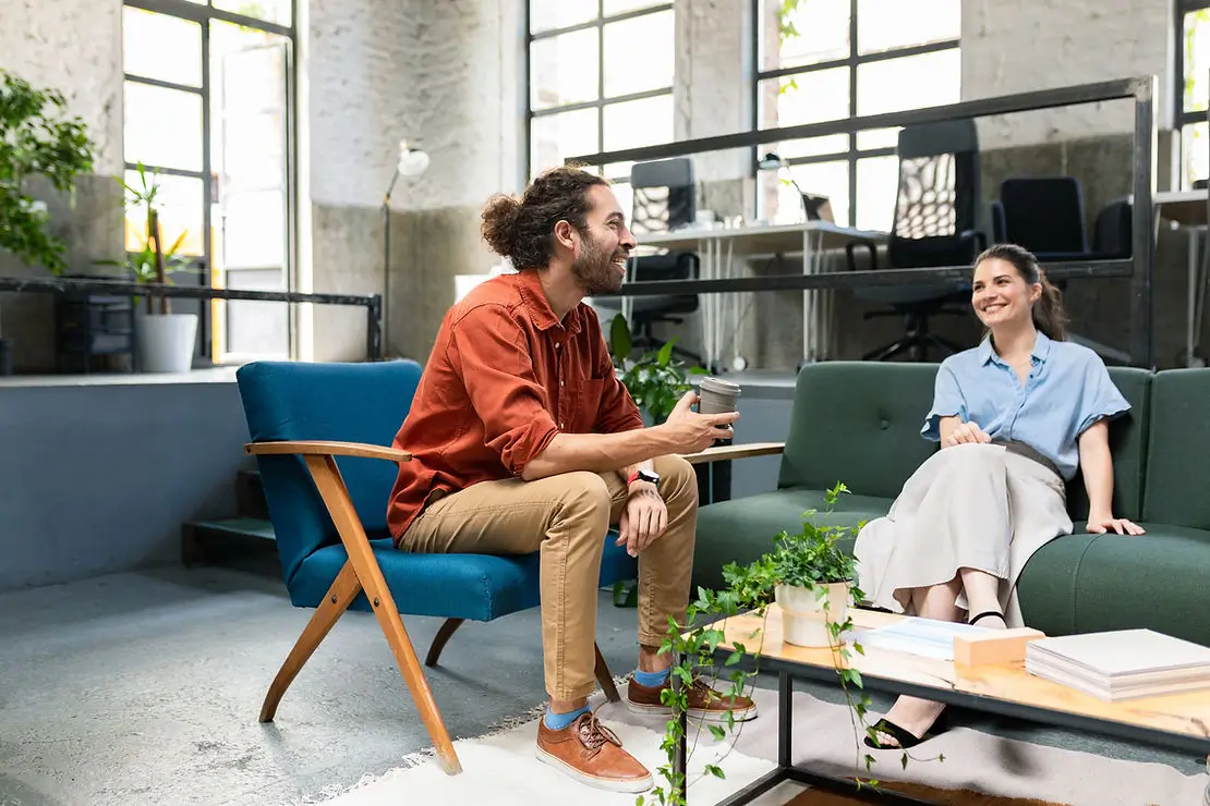 Two people sitting on chairs having a casual meeting