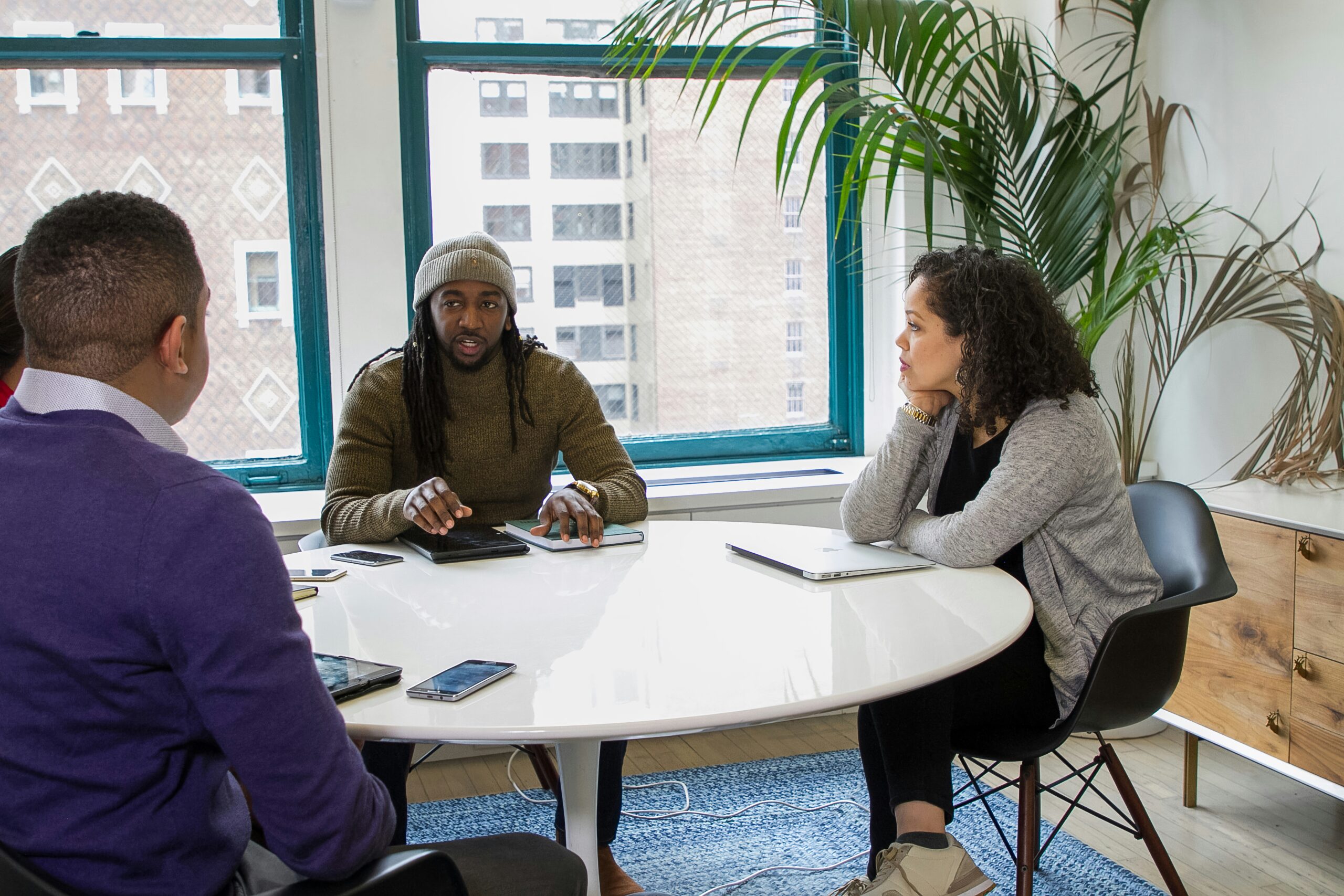 Coworkers sitting at a round table talking.